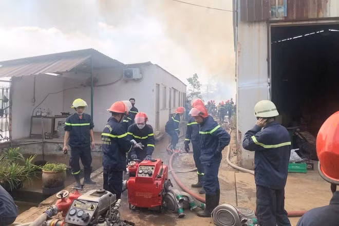 Cảnh sát PCCC kéo đường ống nước tiếp cận xưởng phế liệu. Ảnh: Zingnews.vn