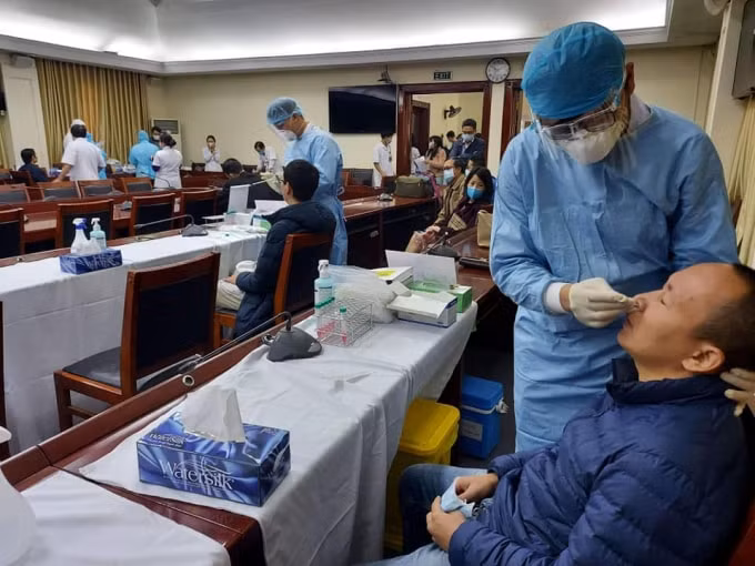 Các phóng viên tham gia đưa tin tại Đại hội Đảng XIII đang được các bác sĩ lấy mẫu xét nghiệm Covid-19