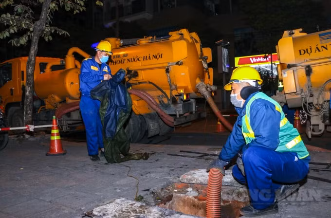 Trên con đường Nguyễn Tuân (quận Thanh Xuân, Hà Nội) có khoảng 10 người công nhân cùng các xe chuyên dụng đang chuẩn bị nhiệm vụ nạo hút cống,