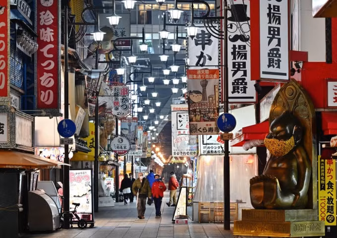 Người dân đi lại thưa thớt ở quận Shinsekai ở Osaka hôm thứ Ba (12/1) - Ảnh: KYODO