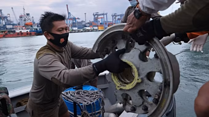 Các nhân viên cứu hộ trục vớt thiết bị của chiếc máy bay gặp nạn - Ảnh: AFP