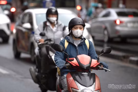 Hình ảnh người Hà Nội mặc áo khoác, áo mưa 'đón' gió lạnh đầu mùa