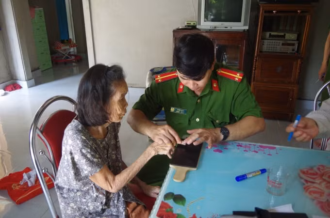 Cán bộ công an Thừa Thiên - Huế đến nhà hỗ trợ người dân cao tuổi làm thủ tục cấp, đổi giấy Chứng minh nhân dân.