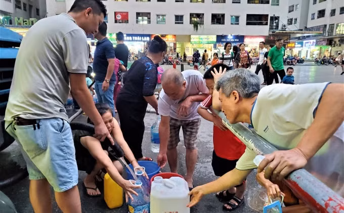 Người dân khu chung cư HH - Linh Đàm xếp hàng, chen chúc để lấy nước sạch như thời bao cấp. Ảnh: TL