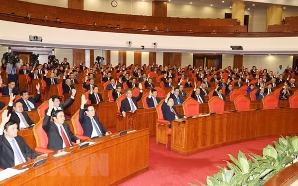 Các đồng chí lãnh đạo Đảng, Nhà nước và các đại biểu biểu quyết thông qua Nghị quyết Hội nghị Trung ương lần thứ 11. Ảnh: TTXVN