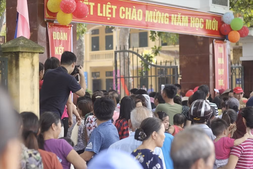 Phụ huynh học sinh Trường Tiểu học Sơn Đồng đứng ngoài cổng trường theo dõi lễ khai giảng của con vào sáng 5/9. Ảnh minh họa.