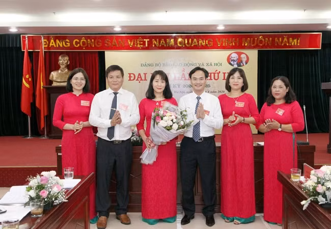 Đồng chí Nguyễn Trung Chính- Phó Bí thư phụ trách Đảng uỷ khoá VIII tặng hoa chúc mừng Ban Chấp hành Đảng ủy khóa IX. Ảnh: Mạnh Dũng