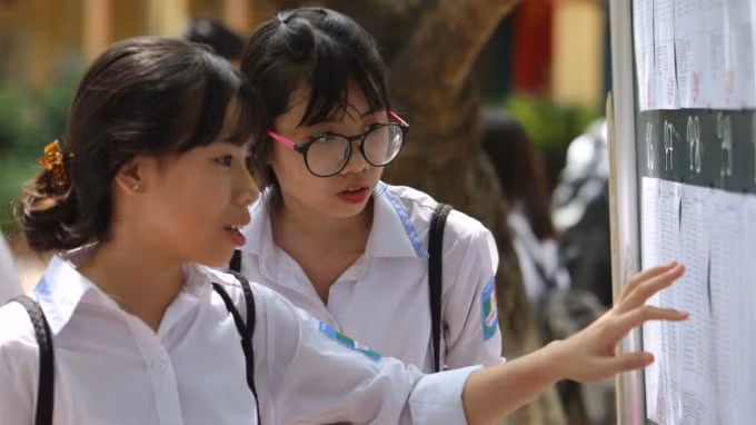 Thí sinh xem danh sách đăng ký dự tuyển lớp 10. Ảnh: TL.