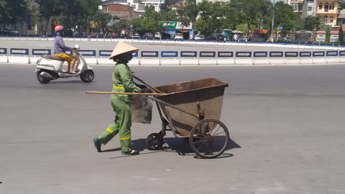 Công nhân vệ sinh môi trường làm việc trong thời tiết nắng nóng, họ vẫn luôn lạc quan làm sạch khắp các phố phường. Ảnh: Quang Linh