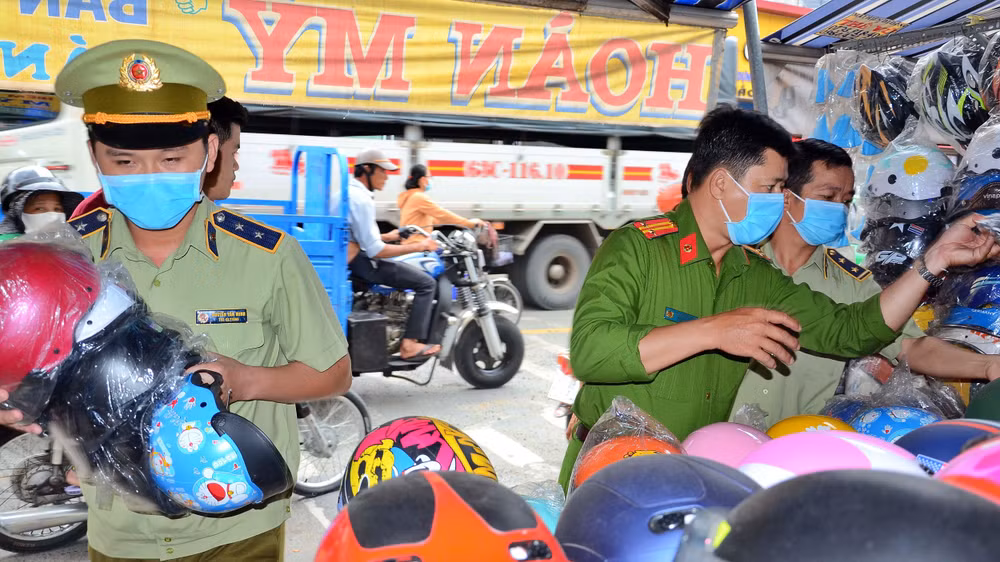 Lực lượng chức năng kiểm tra và thu giữ mũ bảo hiểm giả - Ảnh: Ấp Bắc.