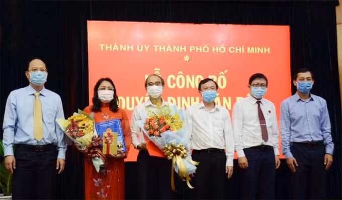 Hai ông bà Phan Văn Thoại và Nguyễn Thị Kim Chi (cầm hoa) nhận quyết định nghỉ hưu trước tuổi. Ảnh thanhuytphcm.vn