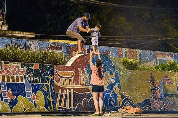 Người dân trèo qua đê để trốn ra khỏi khu phong tỏa. Ảnh: Zing