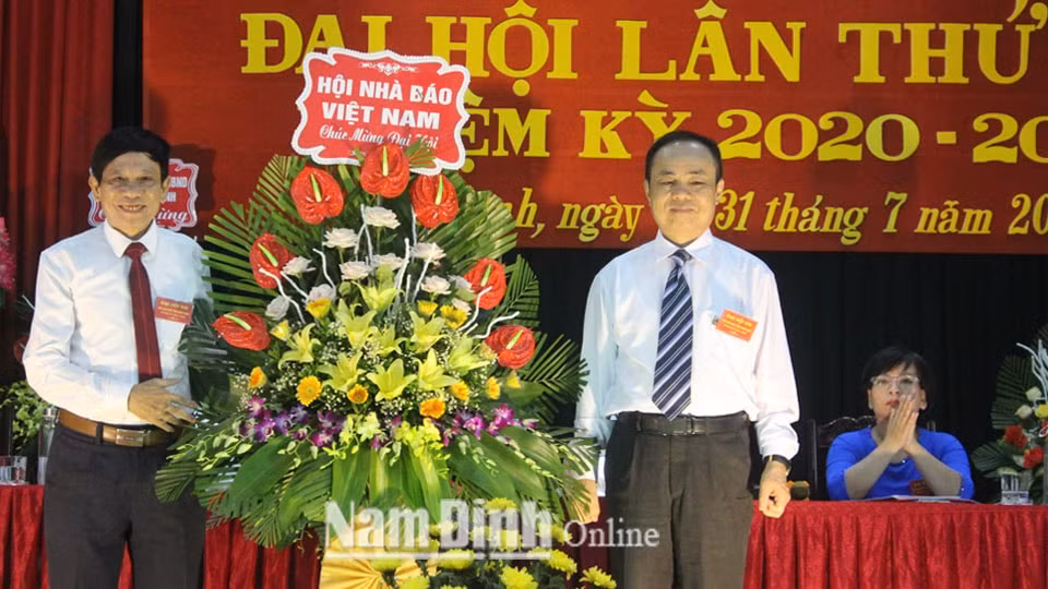 Đồng chí Trần Bá Dung, Uỷ viên Ban thường vụ, Trưởng ban nghiệp vụ Hội Nhà báo Việt Nam trao tặng đại hội lẵng hoa tươi thắm. Ảnh: Hồng Minh