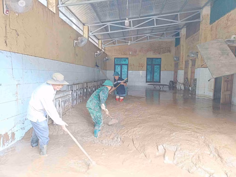Bộ đội, giáo viên vật lộn với khối lượng bùn khổng lồ trong các phòng học. Ảnh: Gia Thảo