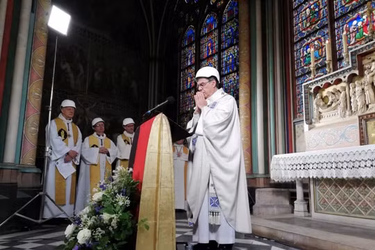 Các cha xứ đội mũ bảo hiểm cầu nguyện tại Notre Dame Paris