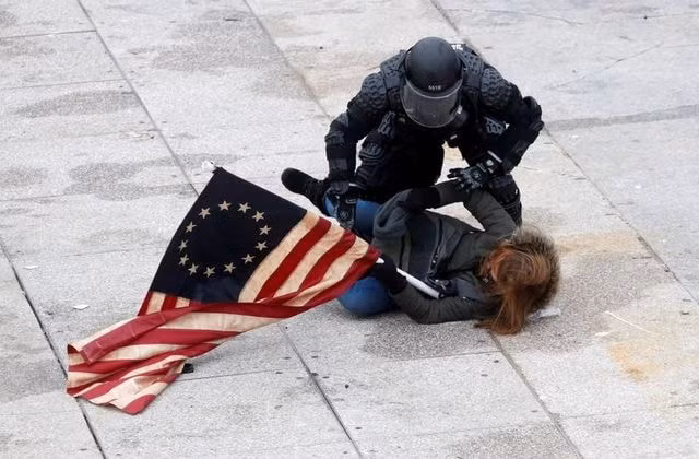 Một phụ nữ tham gia bạo loạn ở điện Capitol bị cảnh sát bắt giữ. Ảnh: Reuters