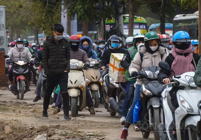 Nhiều phương tiện xe máy sốt ruột đi làm, lao lên vỉa hè để di chuyển.