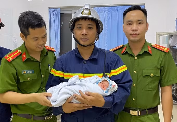 Lực lượng chức năng giải cứu bé sơ sinh ra khỏi khe tường hẹp. Ảnh: TL.