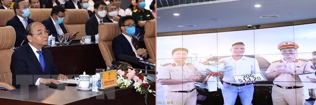 Thủ tướng Nguyễn Xuân Phúc, Chủ tịch Ủy ban Chính phủ điện tử quốc gia và các đại biểu trải nghiệm dịch vụ công quốc gia qua việc bấm biển số tại Phòng CSGT Hà Nội. Ảnh: TTXVN