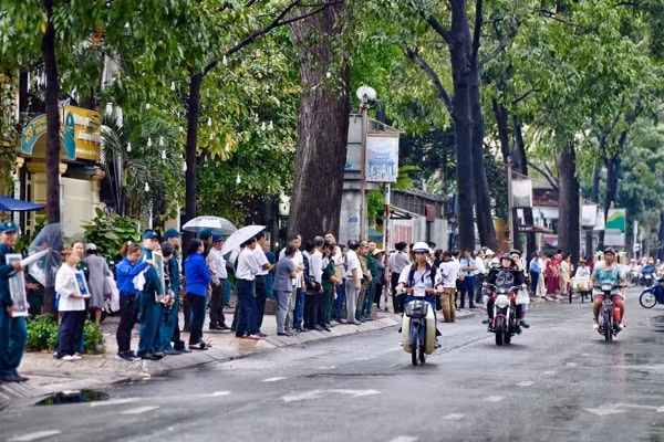 Người dân TP. Hồ Chí Minh đứng dọc hai bên đường chờ đón đoàn xe đưa linh cữu Đại tướng đi qua. Ảnh: TTO