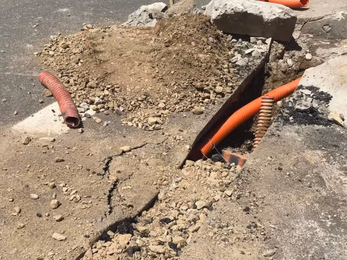 Đường thảm nhựa mới hoàn thành bị cắt để kéo dây điện ngầm