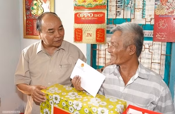 Thủ tướng tặng quà ông Trương Văn Xang, một hộ nghèo bị ảnh hưởng bởi sạt lở. Ảnh: VGP