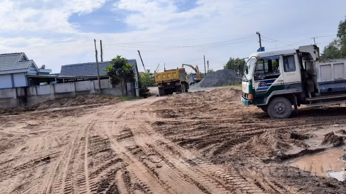 Trên bờ, mặt đường dân sinh bị xe ben trọng tải lớn cày xới nát.