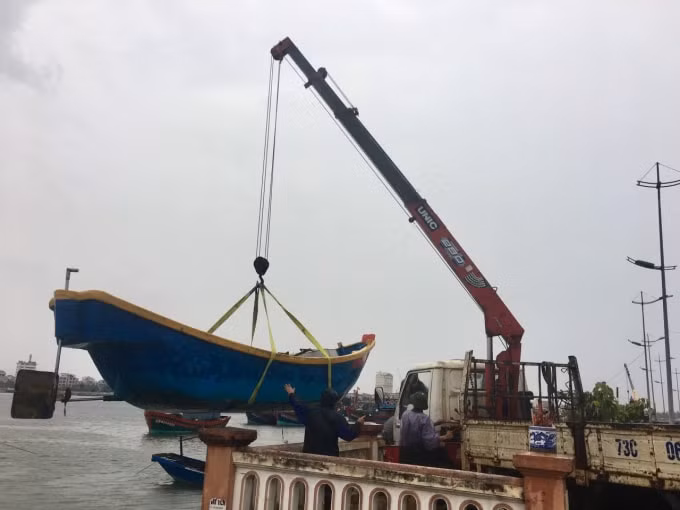 Ngư dân Quảng Bình dùng xe cẩu để cẩu thuyền lên bờ an toàn