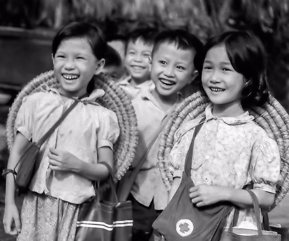Bé đến lớp nơi sơ tán. Con em công nhân Nhà máy in Tiến Bộ, Hà Nội sơ tán về xã Sài Sơn, huyện Quốc Oai, tỉnh Hà Tây, năm 1967. Ảnh: Mầu Hoàng Thiết
