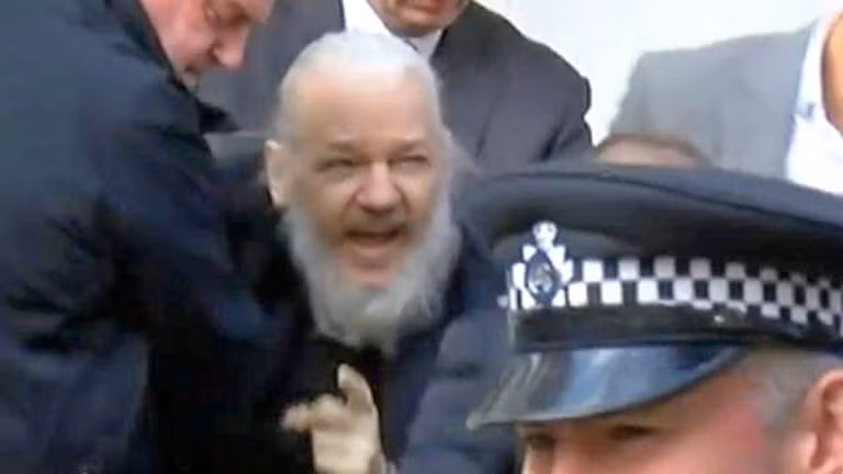 Julian Assange bị cảnh sát Anh lôi ra khỏi đại sứ quán Ecuador ở London. Ảnh: Sky news