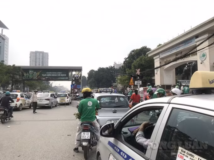 Taxi, xe ôm thản nhiên dừng đỗ tràn lan để đón trả khách trước cổng bệnh viện Bạch Mai