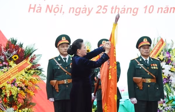 Chủ tịch Quốc hội Nguyễn Thị Kim Ngân gắn Huy hiệu Anh hùng lực lượng vũ trang nhân dân lên Quân kỳ Quyết thắng của Tổng cục II
