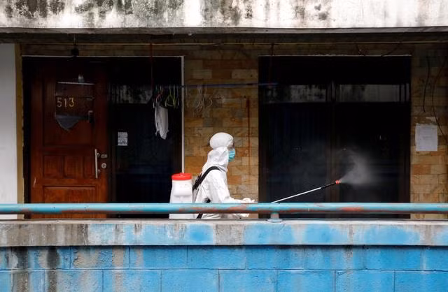 Một nhân viên phun thốc khử trùng tại một chung cư ở Jakarta, Indonesia. Ảnh: Reuters