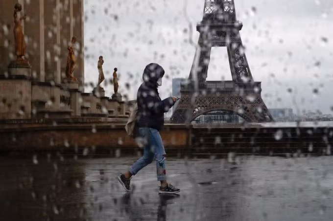 Một người dân đi ngang tháp Eiffel ở Paris, Pháp. Ảnh: Reuters
