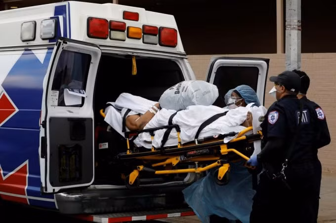 Một bệnh nhân nhiễm virus Corona được vận chuyển lên xe cứu thương tại New York, Mỹ. Ảnh: Reuters