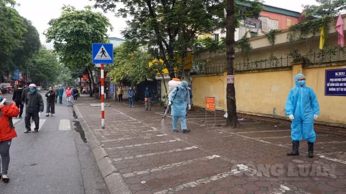 Đồng thời lực lượng chức năng cũng tiến hành khử trùng liên tục tại các vị trí mà người dân xếp hàng. Ảnh H.Long.