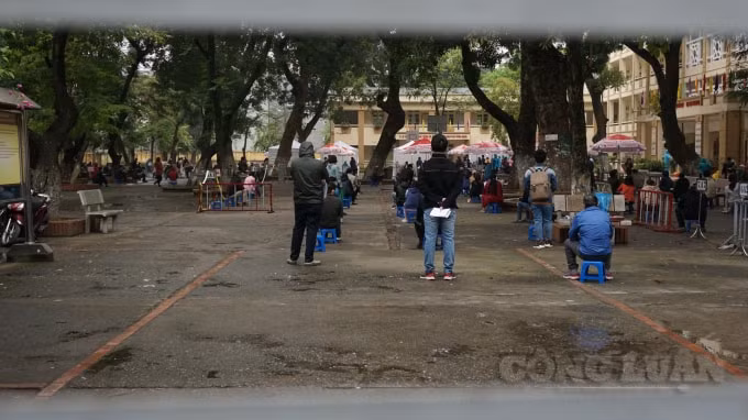 Phía bên trong người dân được xếp ghế ngồi mỗi người cách nhau 2 mét để chờ tới lượt gọi tên lấy mẫu xét nghiệm. Ảnh H.Long.