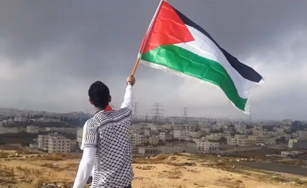 Một người dân cầm cờ Palestine. Ảnh: Unsplash