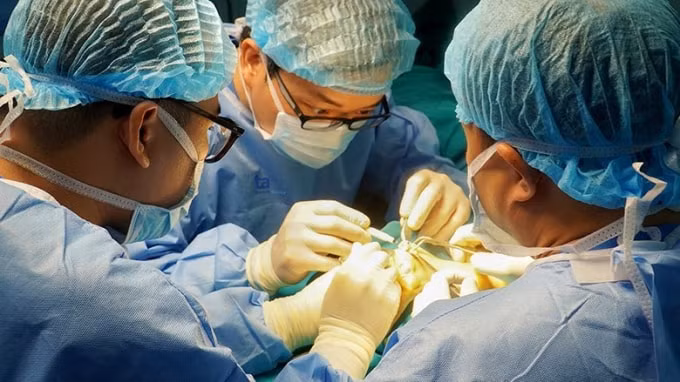 Phó giáo sư Trần Trung Dũng và ekip bác sĩ Trung tâm Phẫu thuật khớp - Y học thể thao Bệnh viện Đa khoa Tâm Anh, Hà Nội phẫu thuật thay đồng loạt 8 khớp ngón tay bị biến dạng cho bệnh nhân Trần Thị Ánh.