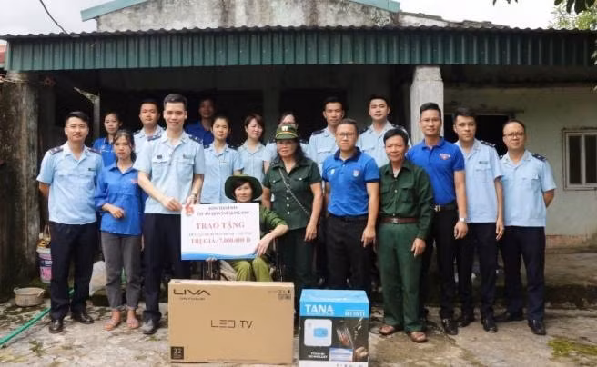Thanh niên tặng quà bà Trần Thị Tay, cựu TNXP (Phường Hải Sơn, TP Móng Cái). Ảnh: Thu Hằng.