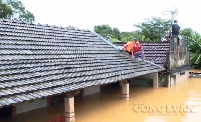 Hàng ngàn ngôi nhà trên địa bàn tỉnh Quảng Trị bị ngập chìm trong nước, người dân phải gỡ ngói để trèo lên nóc.