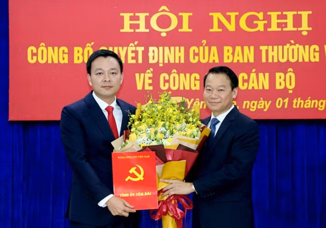 Bí thư Tỉnh ủy Yên Bái Đỗ Đức Duy trao quyết định và tặng hoa chúc mừng ông An Hoàng Linh, tân Bí thư Huyện ủy Yên Bình.