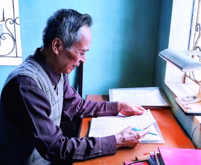 Ông Nguyễn Khắc Nho bên bàn viết.