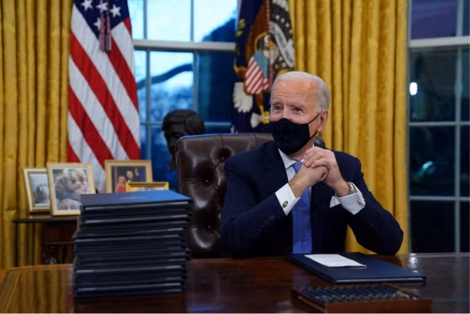 Tổng thống Biden ngồi trong Phòng Bầu dục trong ngày đầu tiên tại Nhà Trắng. Ảnh: Getty