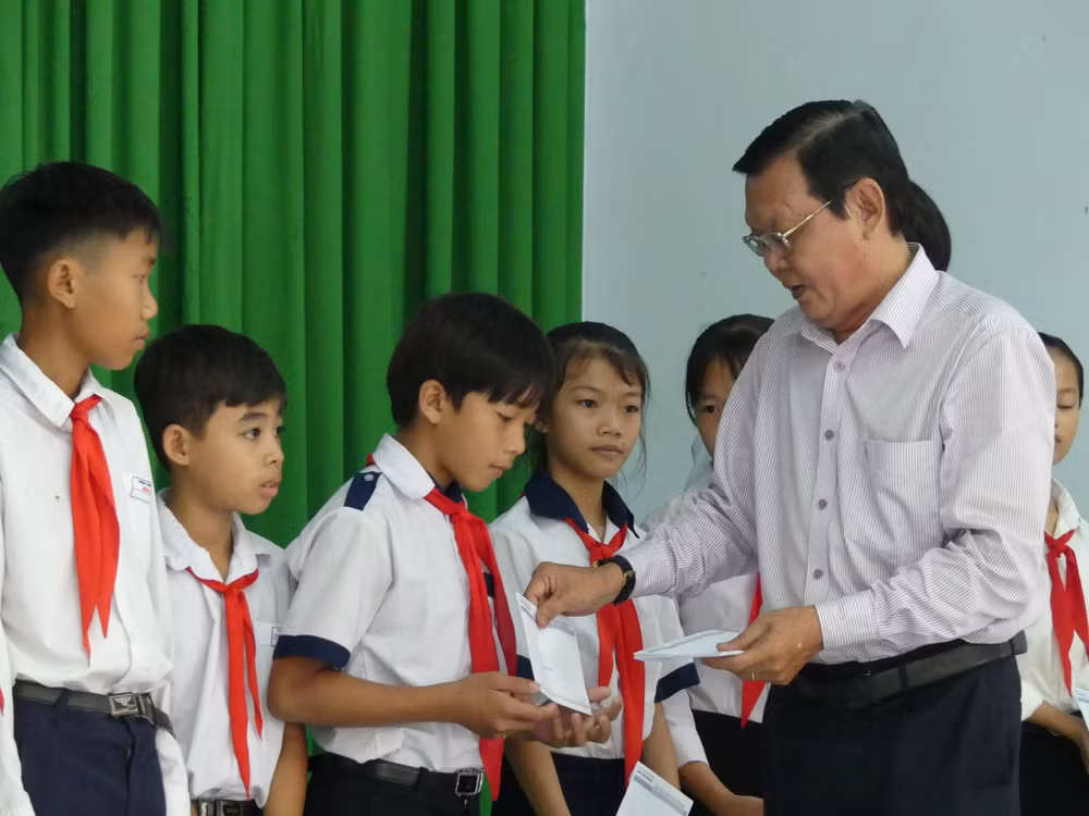 Nhà báo Nguyễn Tấn Phong, Phó Chủ tịch Hội Nhà báo TPHCM trao học bổng cho học sinh. Ảnh: Việt Nga