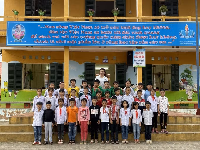 Tiến Anh cùng cô giáo chủ nhiệm và các bạn đồng trang lứa. Ảnh: Thủy Tiên