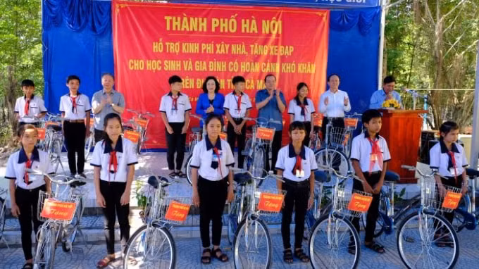 Học sinh trường THCS Đất Mũi, xã Đất Mũi nhận xe đạp do đoàn công tác TP. Hà Nội trao tặng.