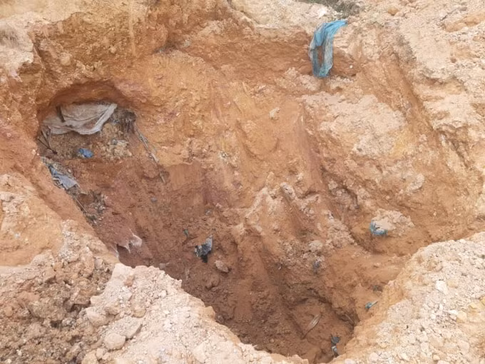 Một trong số những hố chôn được người dân đào lên và phát hiện nhiều tấn chất thải nguy hại. Ảnh Hà Long.