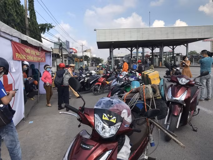 Chủ các phương tiện hướng từ TP. HCM về Đồng Nai thực hiện khai báo y tế và đo thân nhiệt tại chốt dưới chân cầu Đồng Nai - cửa ngõ chính kết nối với TP. HCM.