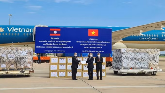 Thứ trưởng Bộ Ngoại giao Tô Anh Dũng trao tượng trưng quà tặng của Đảng, Nhà nước và nhân dân Việt Nam hỗ trợ Đảng, Nhà nước và nhân dân Lào ứng phó dịch Covid-19 cho đồng chí Kikeo Khaykhamphithoun, Ủy viên Bộ Chính trị, Phó Thủ tướng, Chủ tịch Uỷ ban chuyên trách Trung ương về phòng chống COVID-19 của Lào. Ảnh: Bảo Chi